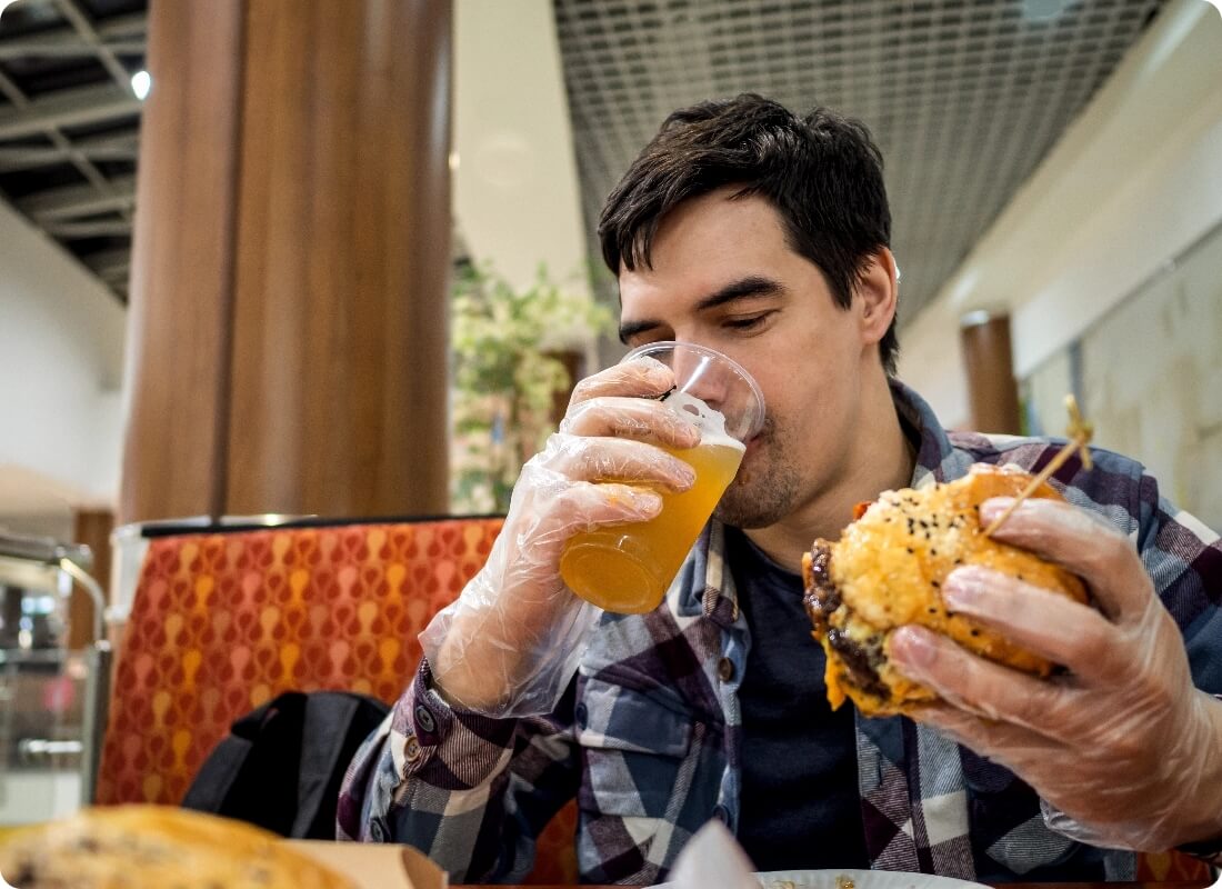 man-eating-fast-food-and-drinking-beer-alone-in-th-2024-09-12-14-15-50-utc@2x