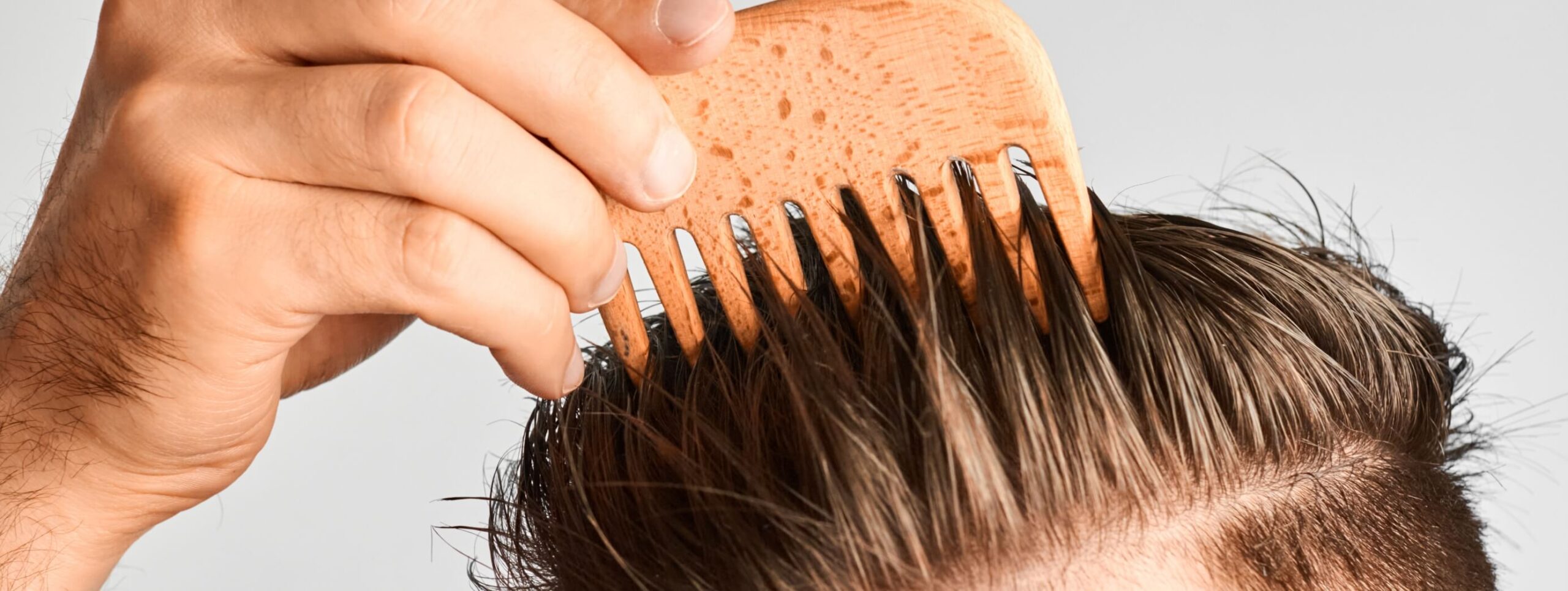 young-man-styling-his-hair-with-a-wooden-comb-hai-2023-11-27-05-34-26-utc (1)