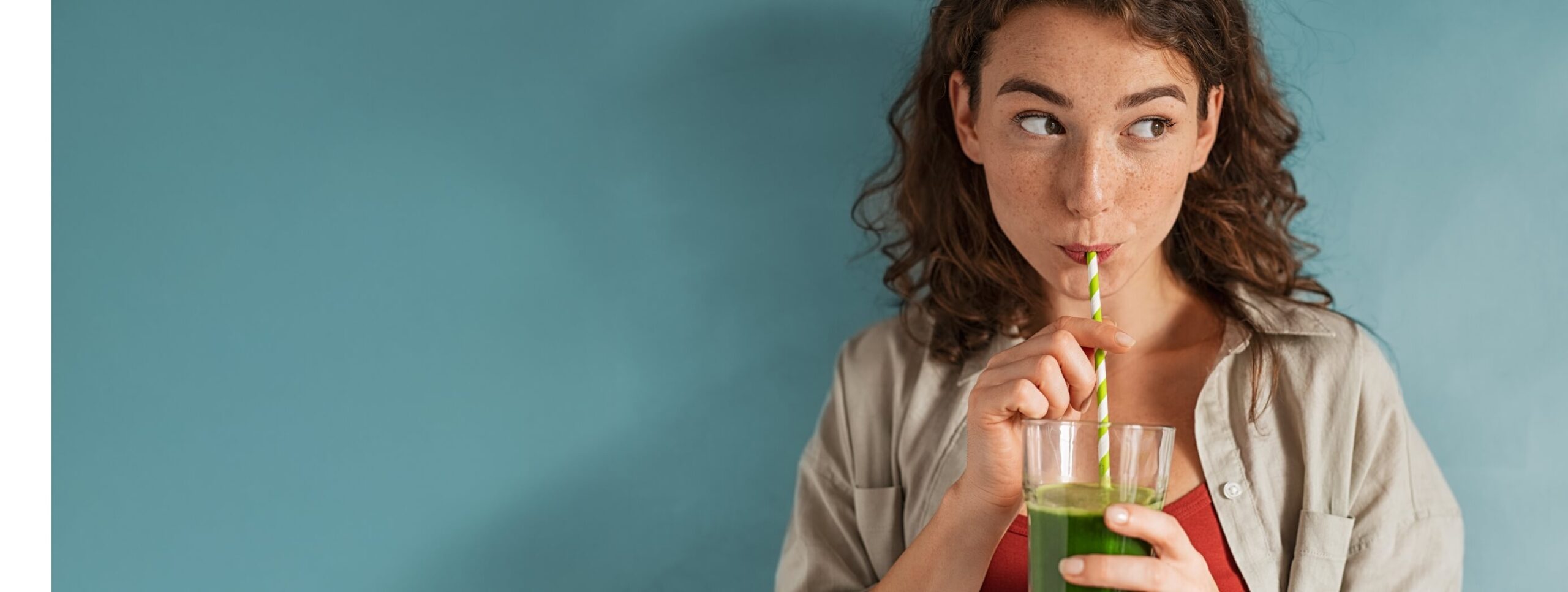 young-woman-drinking-detox-juice-with-straw-on-blu-2023-11-27-05-02-18-utc (1)